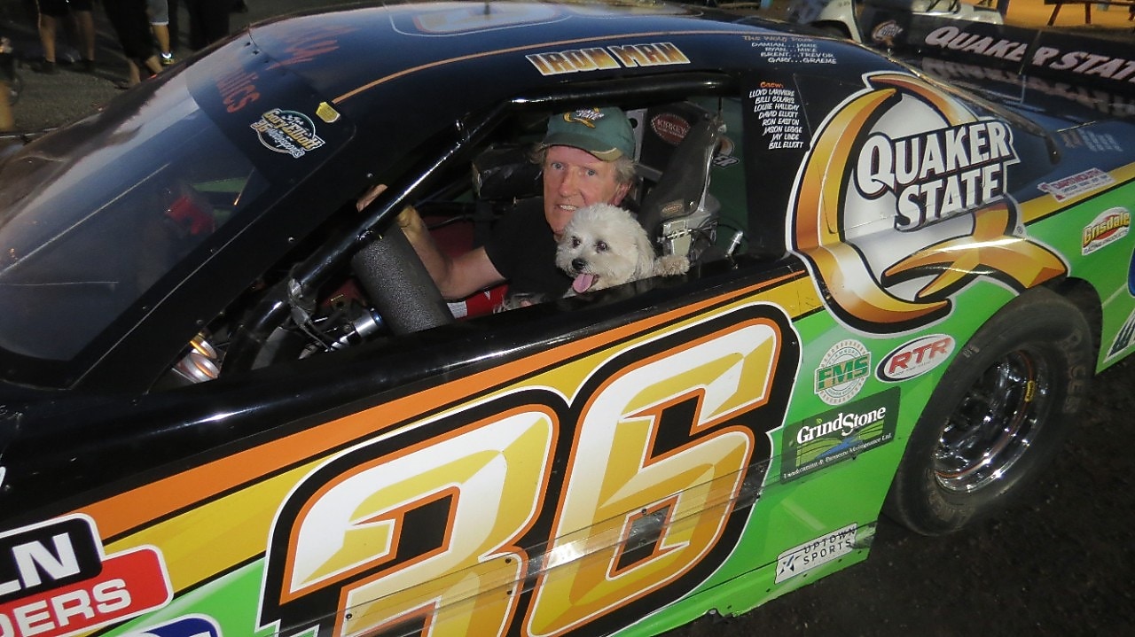 GARY ELLIOTT POSES INSIDE HIS #36 CAR WITH HIS DOG, BUTTONS