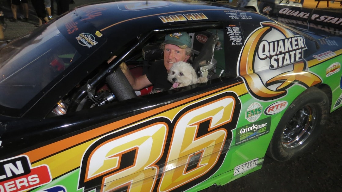 GARY ELLIOTT POSES INSIDE HIS #36 CAR WITH HIS DOG, BUTTONS